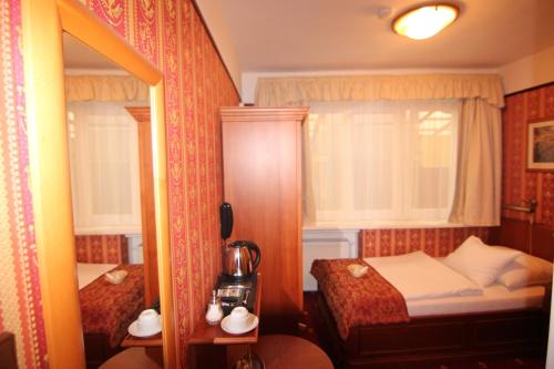 a small bedroom with a bed and a mirror at Old Prague Hotel in Prague
