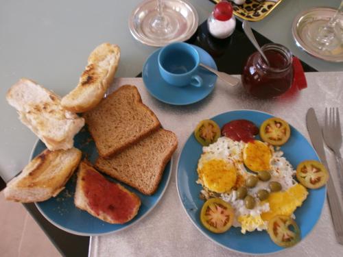 a table with two blue plates of breakfast food at Guesthouse Villa La Isla in La Romana