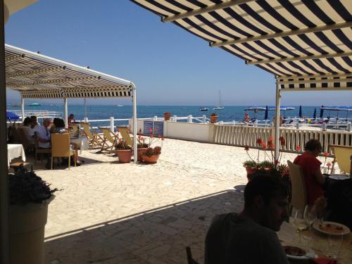 un grupo de personas sentadas en un restaurante con el océano en Hotel Le Najadi, en Santa Marinella