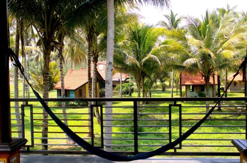 a hammock in front of a fence with palm trees at Arrys Watukarung Surfcamp in Kalak