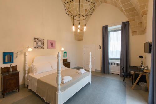 una camera con letto, tavolo e finestra di Vinilia Wine Resort a Manduria
