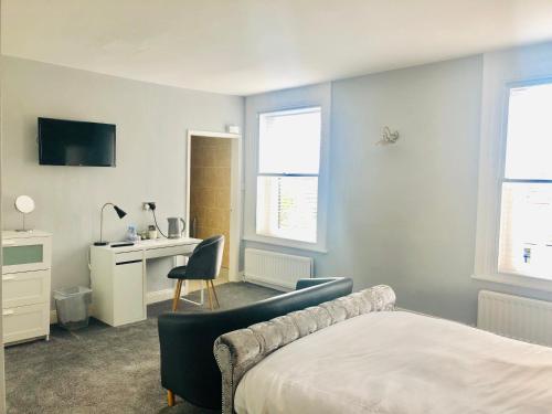a bedroom with a bed and a desk and a chair at Hardwick Arms Hotel in Sedgefield