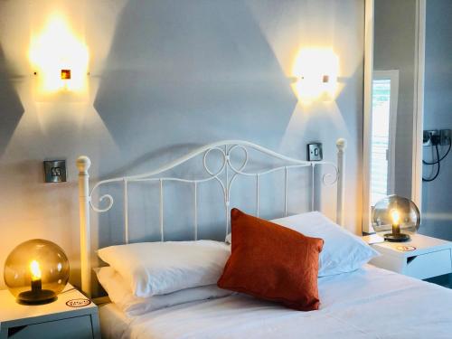 a bedroom with a white bed with two lights on it at Hardwick Arms Hotel in Sedgefield