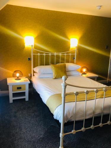 a bedroom with a large bed with two lamps on it at Hardwick Arms Hotel in Sedgefield