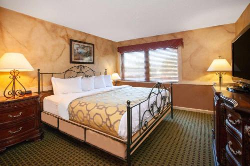 a bedroom with a bed and a desk and a window at Baymont by Wyndham Franklin in Franklin