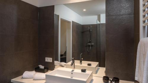 a bathroom with two sinks and a mirror at Blackhome Graz I contactless check-in in Graz