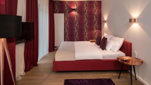 a bedroom with a bed with a red wall at Blackhome Graz I contactless check-in in Graz