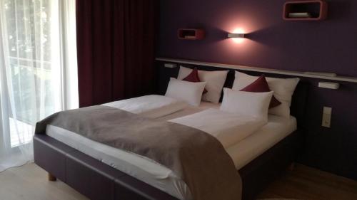 a bedroom with a large bed with white and red pillows at Blackhome Graz I contactless check-in in Graz