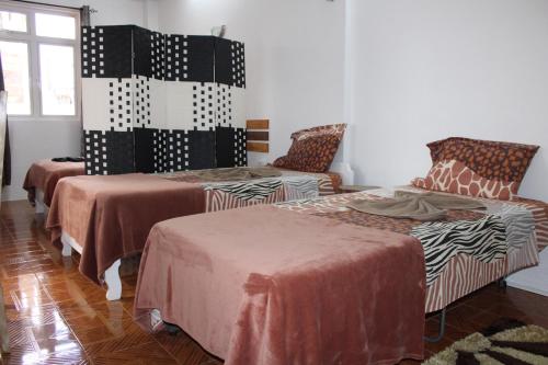 a room with two beds and a chair at Le Pôle in Grand Baie