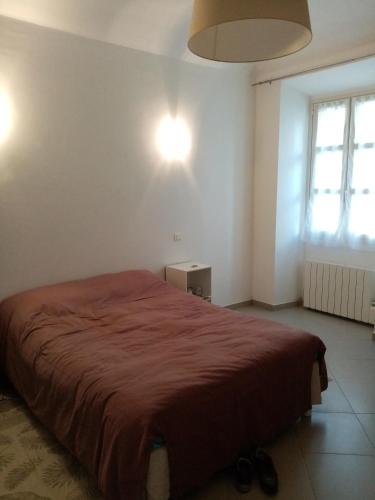 une chambre avec un grand lit avec une couverture rouge dans l'établissement Appartement cours Bonaparte, à Sartène