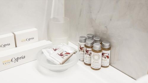 a white bathroom with four bottles of spices on a counter at Athens Cypria Hotel in Athens