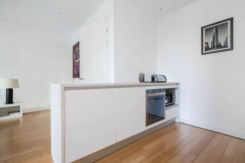 a kitchen with white cabinets and a counter top at Quartermile Central Apartment in Edinburgh