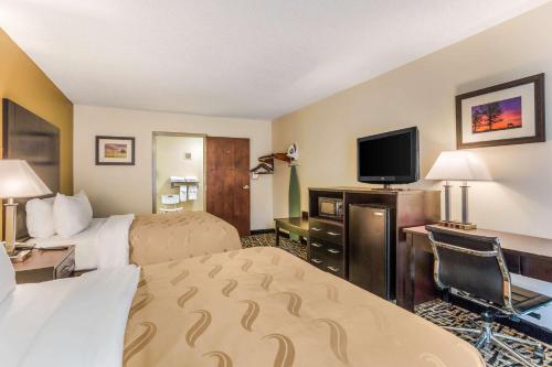a hotel room with a bed, television and a fireplace at Quality Inn Russellville in Russellville