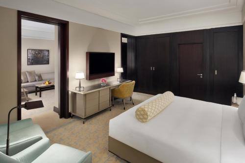 a hotel room with a bed and a television at The Hotel Galleria Jeddah, Curio Collection by Hilton in Jeddah