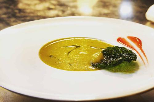 a white plate with a piece of broccoli and sauce at Galerie Hotel in Paderborn
