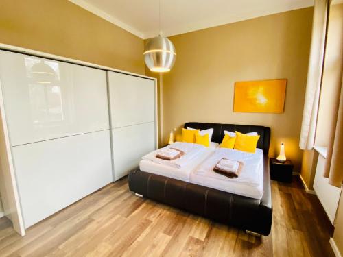 um quarto com uma cama com almofadas amarelas em Villa Anna - Vis à vis em Heringsdorf