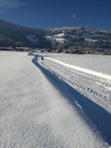 a shadow of a person on a snow covered beach at Ferienhaus Oberhuben in Fügenberg