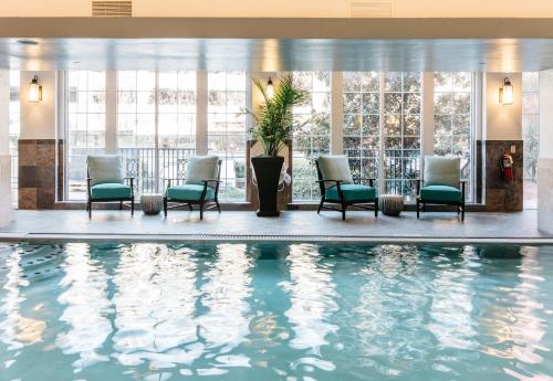 a hotel lobby with a pool with chairs and windows at The Read House, Downtown City Center in Chattanooga