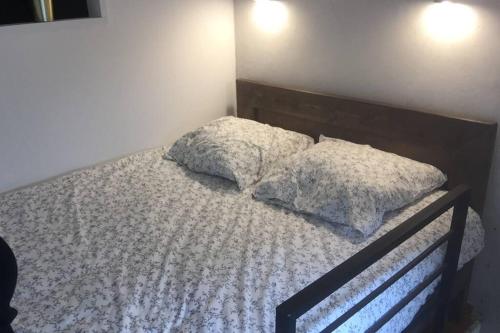 une chambre avec un lit avec deux oreillers dessus dans l'établissement STUDIO TOUT ÉQUIPÉ, à Marguerittes