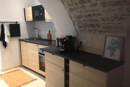 une cuisine avec un comptoir noir dans une pièce dans l'établissement STUDIO TOUT ÉQUIPÉ, à Marguerittes