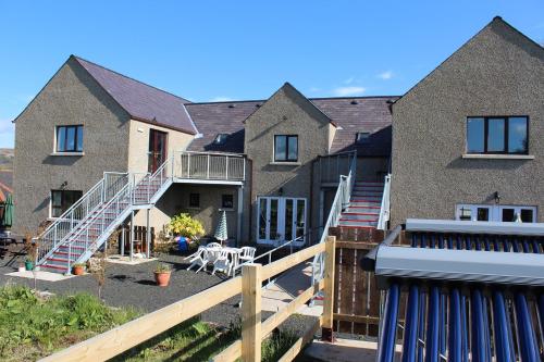 a house with a deck and stairs in front of it at Slemish Barn Hostel in Ballymena