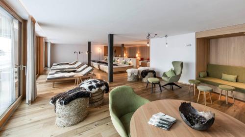 ein Wohnzimmer mit einem Tisch und Stühlen in der Unterkunft Feuerstein Nature Family Resort in Gossensaß