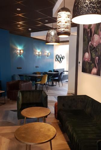 a waiting room with couches and tables and chairs at Hotel de Champagne in Épernay
