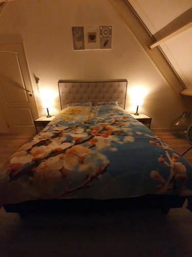 a bed in a room with two lamps on tables at Bed & breakfast FF rust in Kockengen