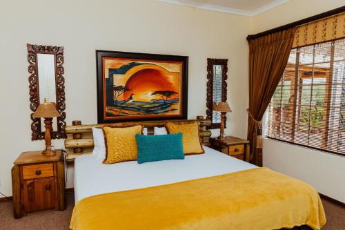 a bedroom with a bed with yellow and blue pillows at Boubou Bed and Breakfast in Rustenburg