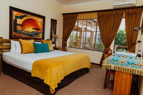 
a bedroom with a bed and a painting on the wall at Boubou Bed and Breakfast in Rustenburg
