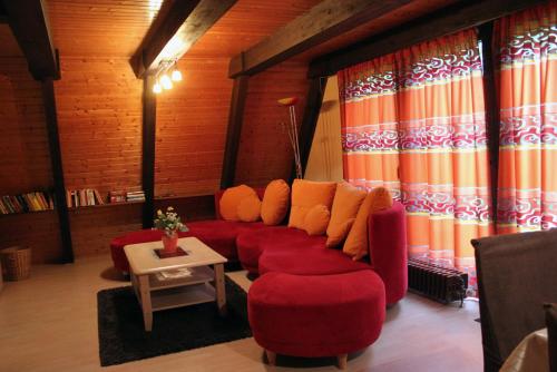 a living room with red couches and a table at Ferienhaus Kirschblüte in Ronshausen