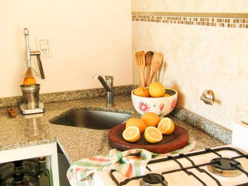 a kitchen counter with a bowl of oranges on a cutting board at Apartamento in Villa Elisa