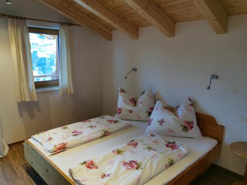 twee bedden in een kleine kamer met een raam bij s' Riedlhof Zuhäusl in Oberau