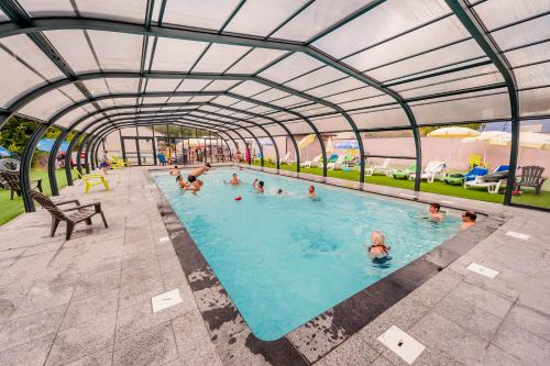 a group of people swimming in a swimming pool at Budget Glamping Safaritent - La Steniole in Barbey-Séroux