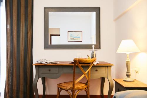 a desk in a room with a mirror and a chair at Hotel Enterprise in Montalto di Castro