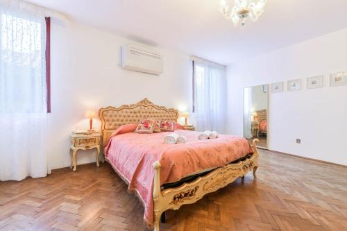 ein Schlafzimmer mit einem großen Bett mit einer rosa Tagesdecke in der Unterkunft Ca Virgilio in Venedig
