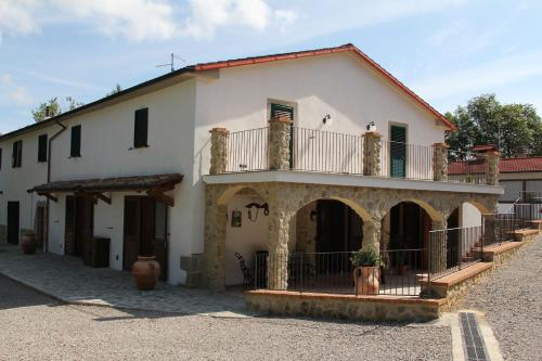 a large white house with a balcony on top at Agriturismo Le Paicciole in CastellʼAzzara