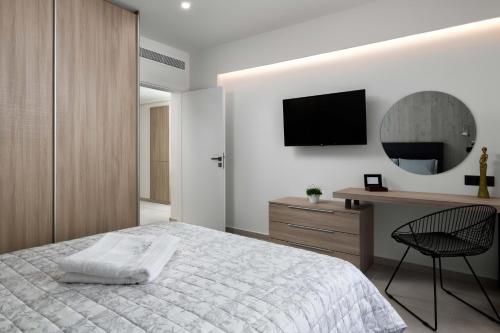 a bedroom with a bed and a desk and a television at Kallia Sea Breeze - 3 Bedroom Apartment in Rhodes Town