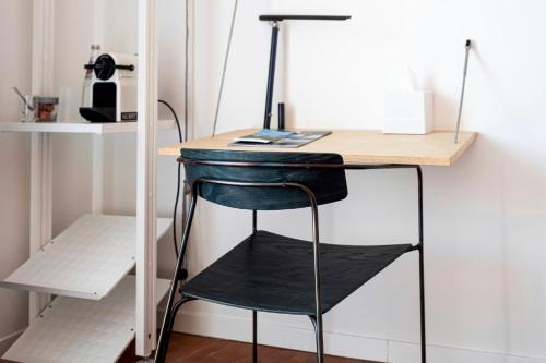 a desk with a chair and a laptop on it at Hôtel La Reine Jane in Hyères
