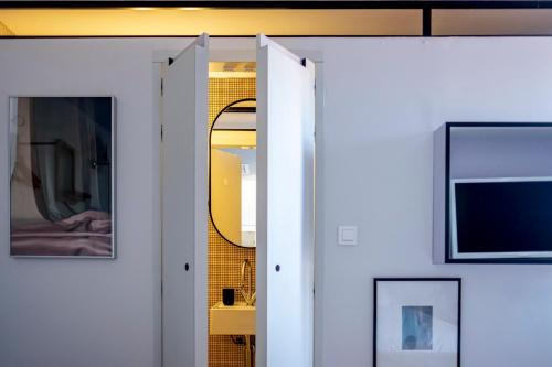 a room with a white door and a mirror at Hôtel La Reine Jane in Hyères