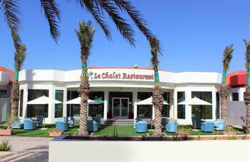 a hotel with palm trees in front of it at Royal Residence Hotel Apartments in Umm Al Quwain