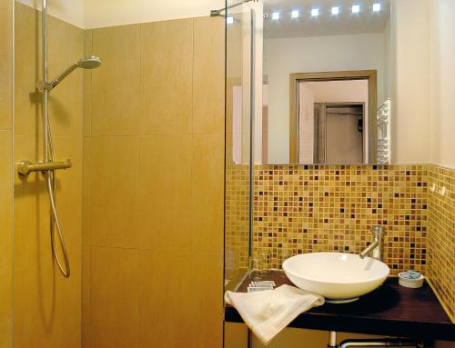 La salle de bains est pourvue d'un lavabo et d'une douche. dans l'établissement Hotel Andreas, à Dresde