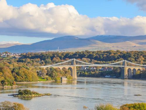 a bridge over a river with mountains in the background at Manadwyn in Menai Bridge