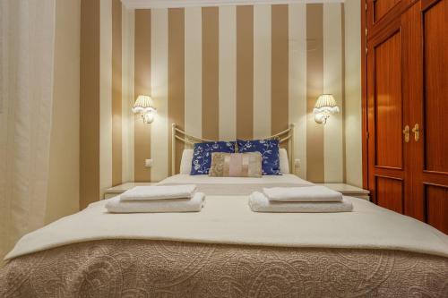 a bedroom with a large bed with towels on it at Descanso-elegancia en Sevilla Parking Gratuito in Seville