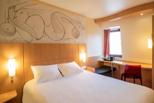 Habitación de hotel con cama, escritorio y ventana en ibis Le Mans Centre, en Le Mans