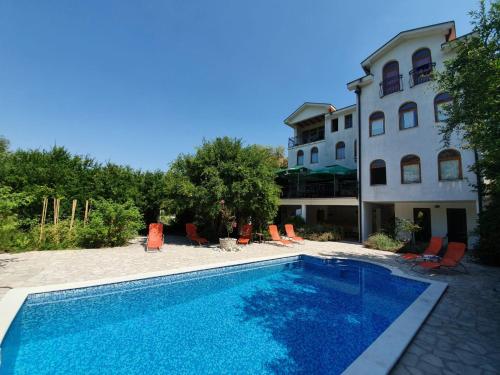 a swimming pool in front of a house at Villa Velagic in Blagaj