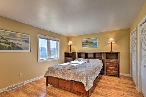 a bedroom with a bed and two windows at East of the Sun Beachside Apartment with Deck! in Emerald Isle