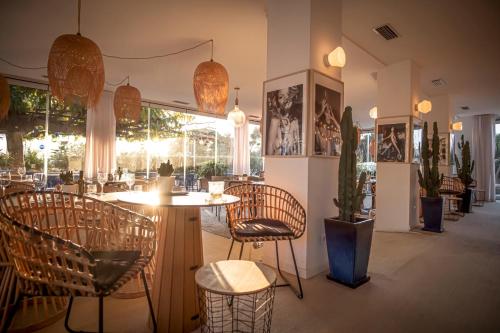 a restaurant with chairs and a table in a room at Hôtel La Reine Jane in Hyères