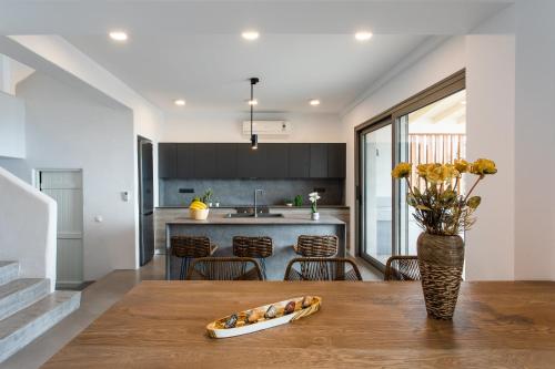 a kitchen with a wooden table with a vase of flowers at DEVELIKIA PRIVATE VILLA 2 - Ierissos in Ierissos