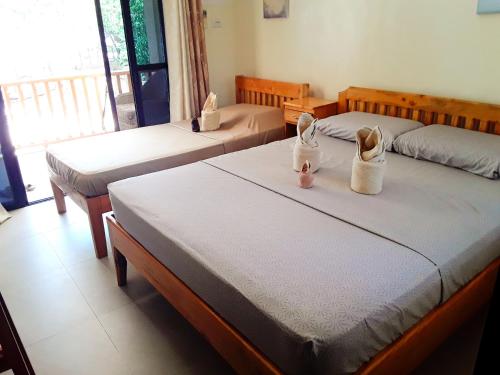a room with two beds with shoes on them at Adayo Cove Resort in Siquijor